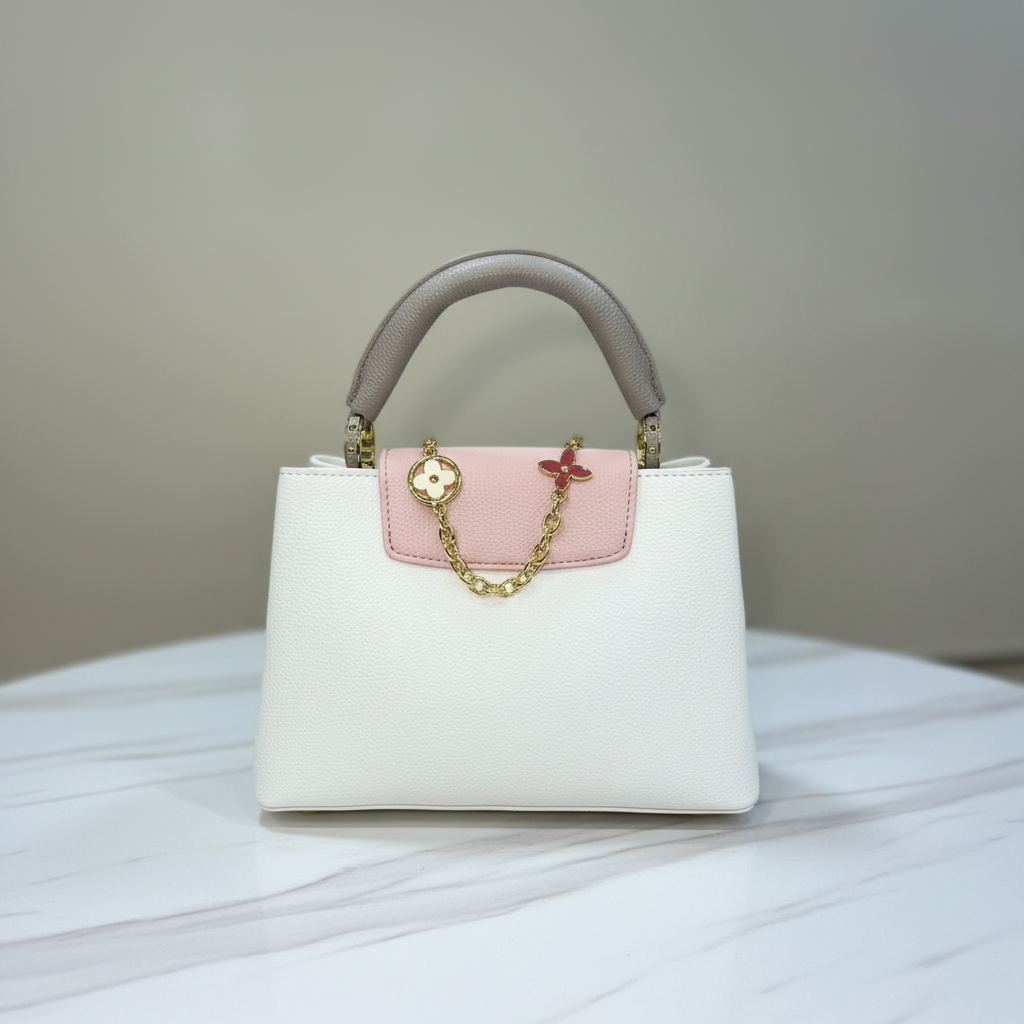 Louis Vuitton Capucines Cream White chain charm detail on white marble