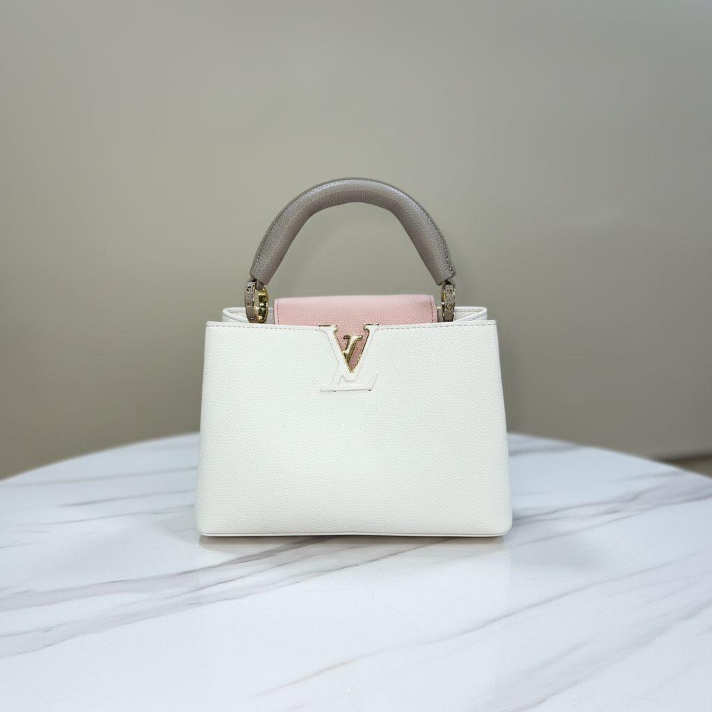 Louis Vuitton Capucines Cream White LV clasp reverse view on white marble