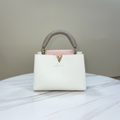 Louis Vuitton Capucines Cream White LV clasp reverse view on white marble