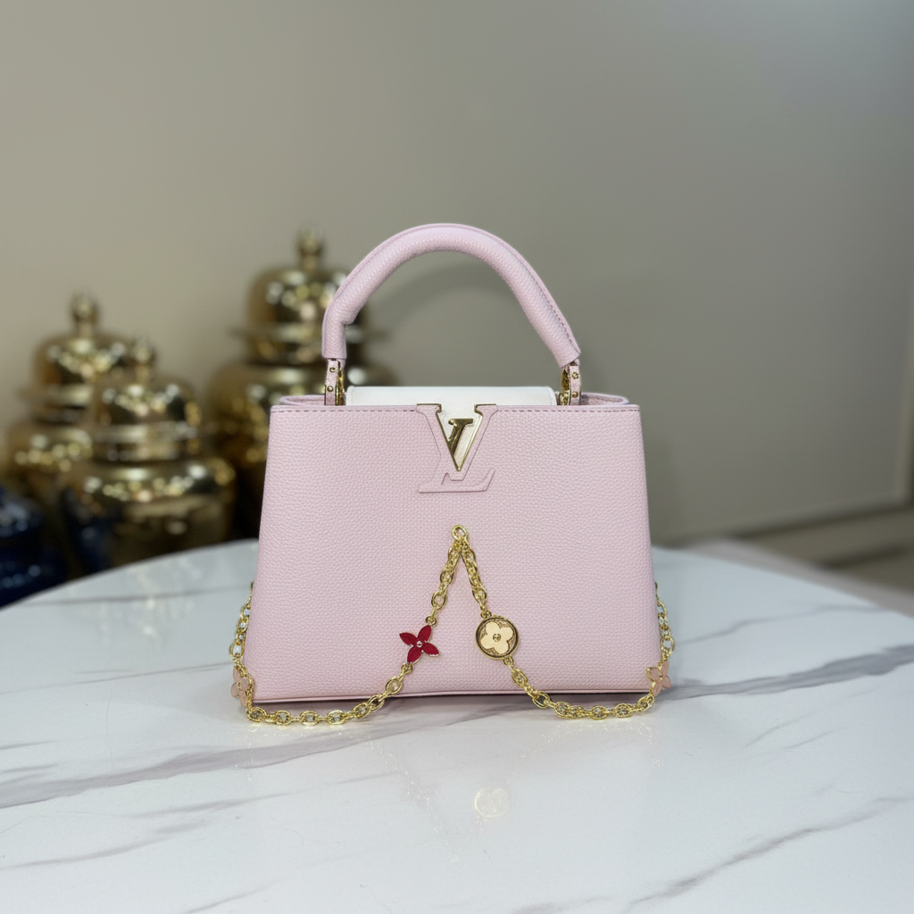 Louis Vuitton Capucines Blush Pink front full charms view on white marble