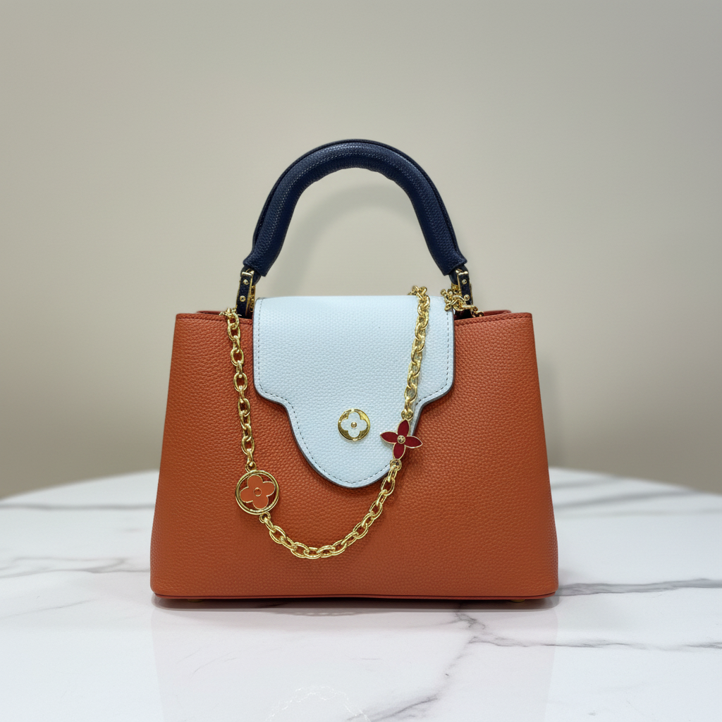 Louis Vuitton Capucines Orange Rust front view on white marble