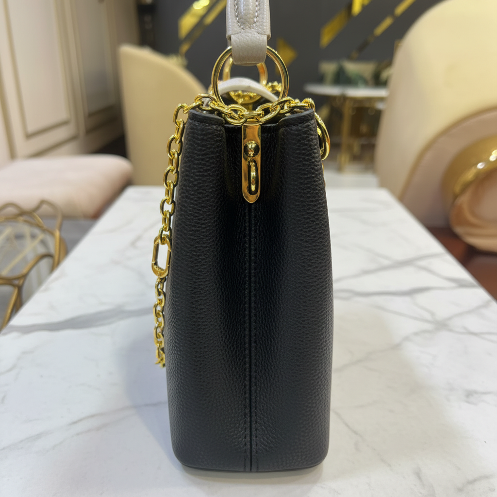Louis Vuitton Capucines BB Black White Flap side hardware on white marble