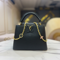 Louis Vuitton Capucines All Black front LV logo on white marble